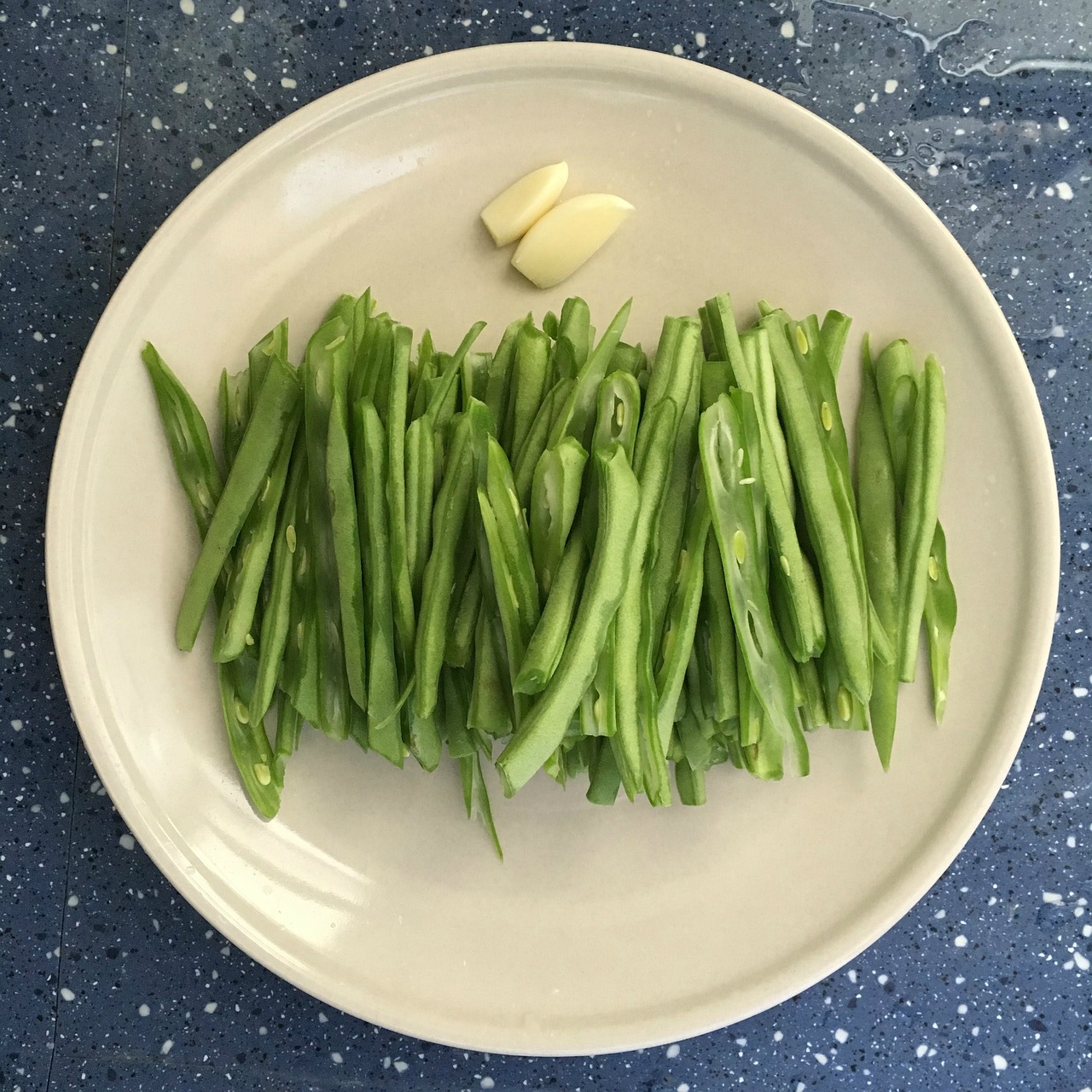 plate of green beans and a clove of garlic